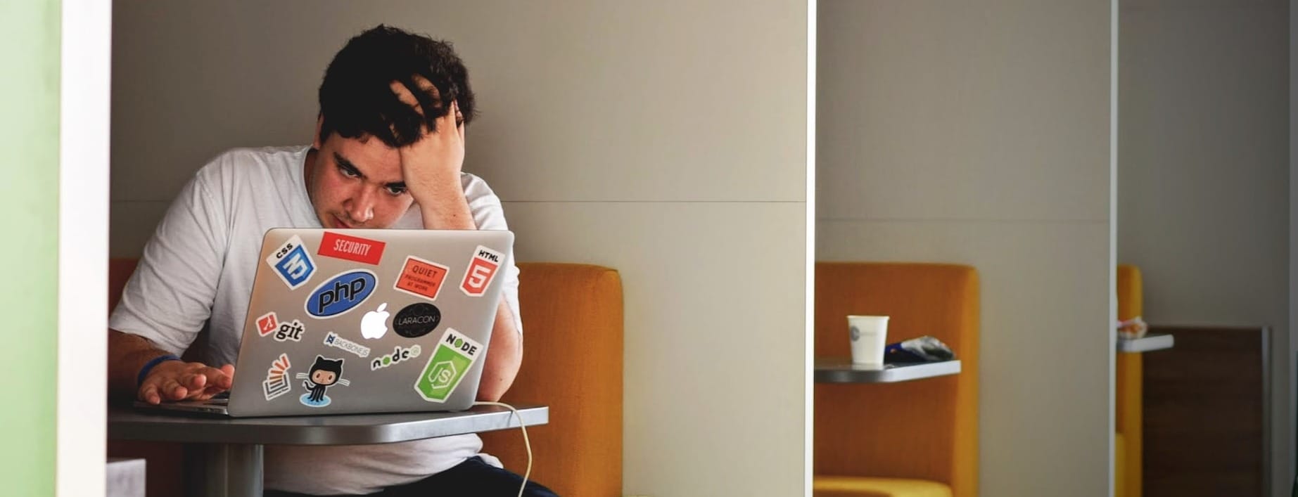 man wearing white top using MacBook